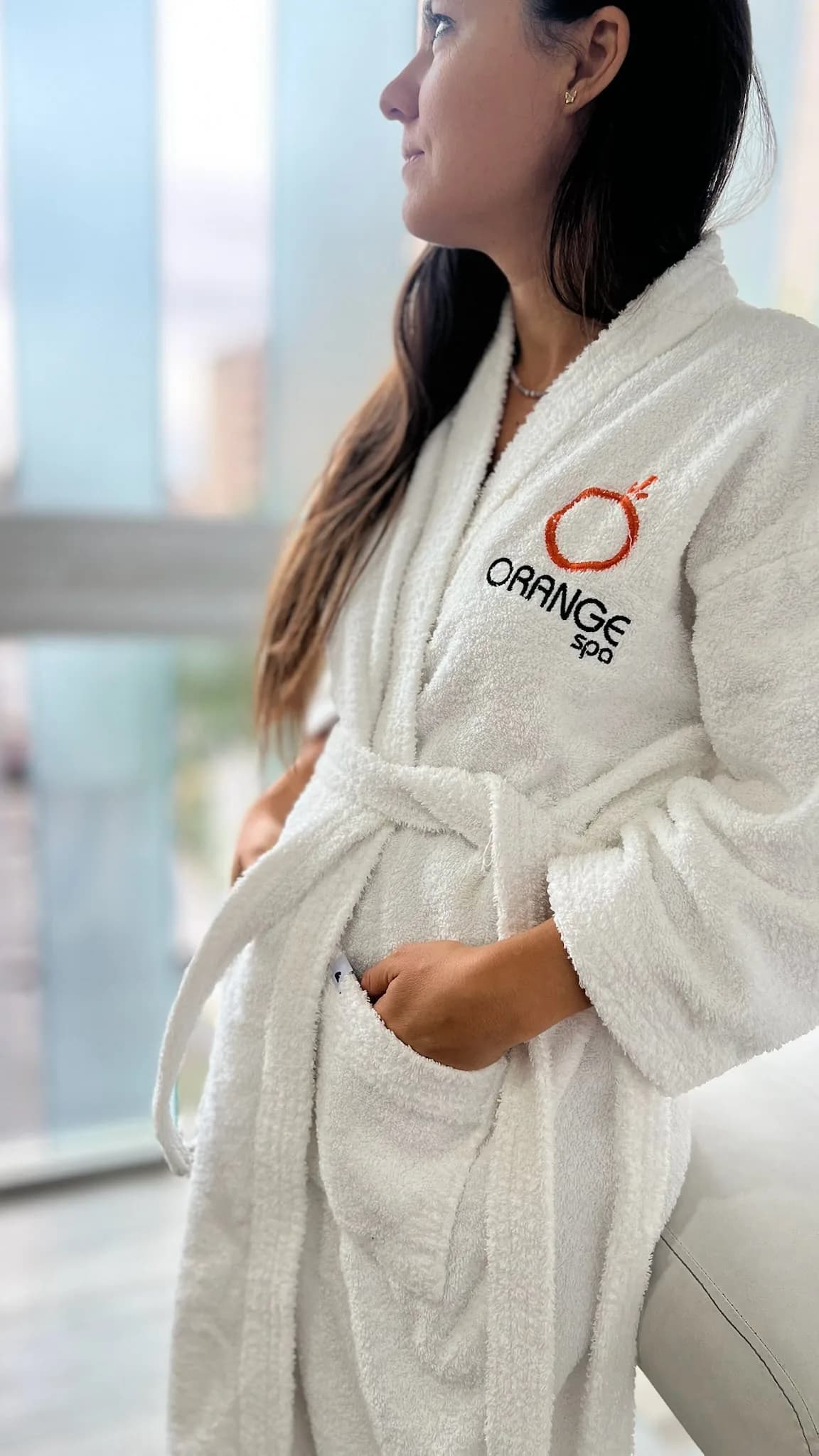 Detalle de una bata blanca con el logo bordado de Orange Spa