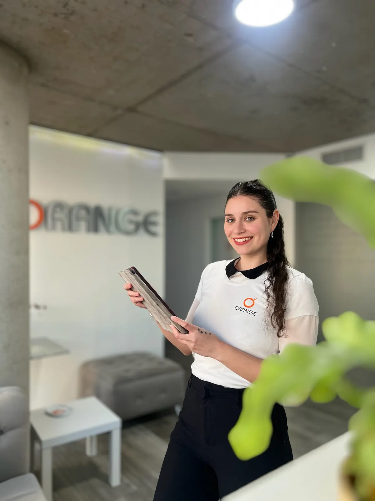 Integrante del equipo de Orange con una tablet en la recepción del centro